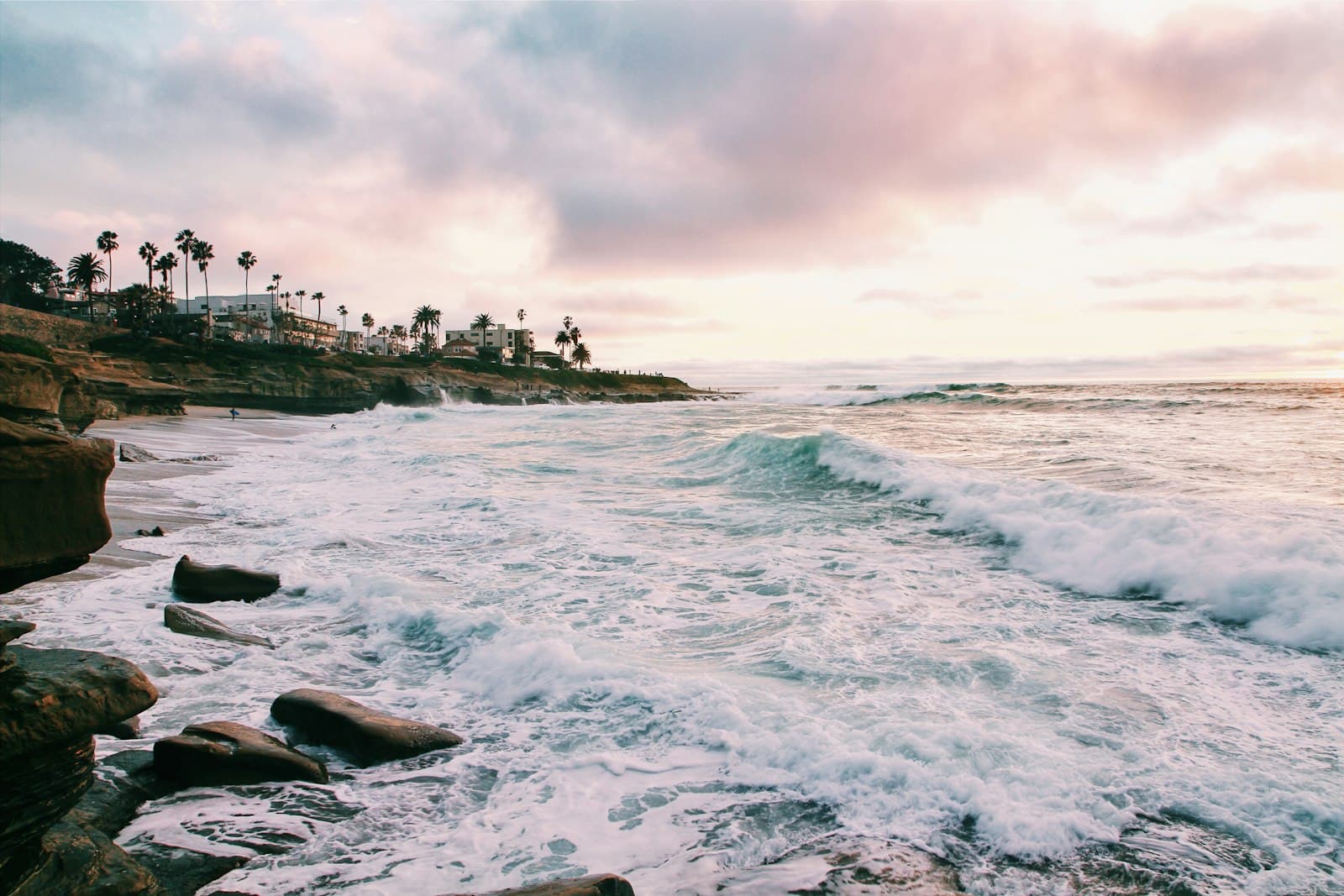 Waves crashing on the San Diego shoreline at golden hour