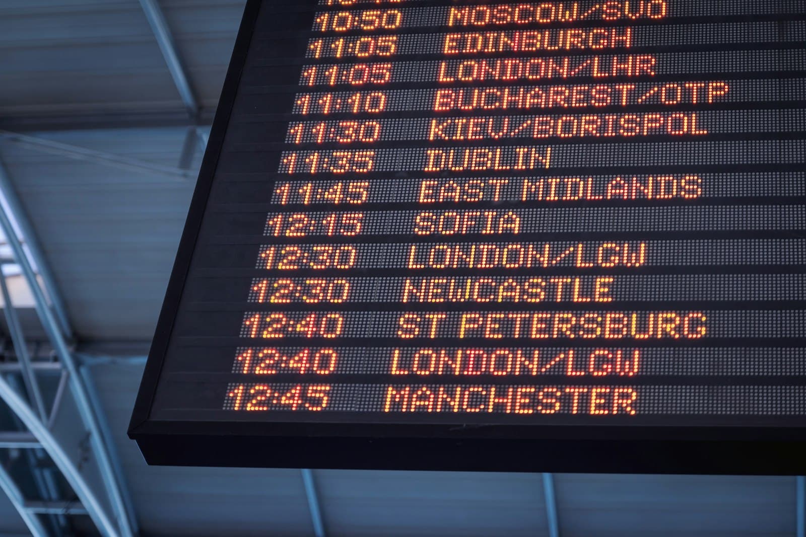 Airport departures board showing flight times and destinations